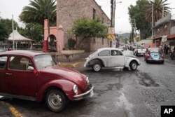Volkswagen Beetles circulate offering taxi service in the hilly Cuautepec neighborhood of Mexico City, Friday, June 21, 2024. (AP Photo/Aurea Del Rosario)