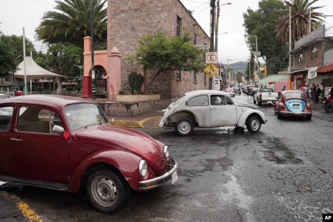 Volkswagen Beetles circulate offering taxi service in the hilly Cuautepec neighborhood of Mexico City, Friday, June 21, 2024. (AP Photo/Aurea Del Rosario)