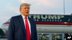 Former President Donald Trump speaks with reporters before departing from Hartsfield-Jackson Atlanta International Airport, Aug. 24, 2023, in Atlanta.