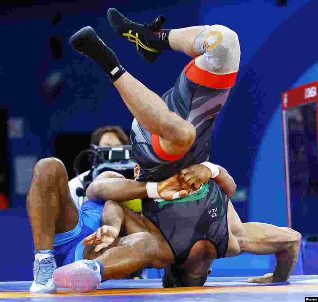 Pegulat Zhan Beleniuk dari Ukraina dan Alireza Mohmadipiani dari Iran bertanding dalam semifinal nomor gulat Yunani-Romawi putra 87kg di Olimpiade Paris 2024 di Champ-de-Mars Arena di Paris, Prancis. (Reuters)