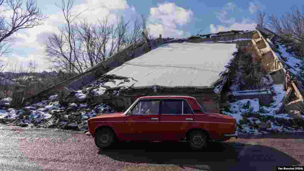 An old Soviet Lada passes by one of the many bridges that were destroyed in Kupiansk in the last months, Feb. 17, 2023.