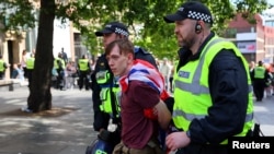 FILE - An anti-immigration protester is detained by police officers, in Newcastle, Britain Aug. 10, 2024. 