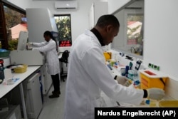 Teknisi laboratorium Xolile Mhlanga bekerja dengan botol-botol lenacapavir di Situs Penelitian Masiphumelele milik Desmond Tutu Health Foundation, di Cape Town, Afrika Selatan, Selasa, 23 Juli 2024. (Nardus Engelbrecht/AP)