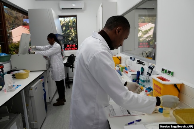 Teknisi laboratorium Xolile Mhlanga bekerja dengan botol-botol lenacapavir di Situs Penelitian Masiphumelele milik Desmond Tutu Health Foundation, di Cape Town, Afrika Selatan, Selasa, 23 Juli 2024. (Nardus Engelbrecht/AP)