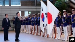 Президент Южной Кореи Юн Сок Ёль (в центре) и премьер-министр Японии Фумио Кисида (слева) принимают участие в церемонии почетного караула перед их двусторонней встречей в офисе премьер-министра в Токио, 16 марта 2023 года.
