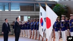 South Korean President Yoon Suk Yeol, center, and Japanese Prime Minister Fumio Kishida, left, attend an honor guard ceremony, ahead of their bilateral meeting at the Prime Minister's Office, in Tokyo, March 16, 2023.
