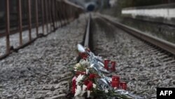 A photo shows flowers layed on the tracks at the railway station of Rapsani, north Greece, on March 5, 2023, during a commemorative gathering for the victims of a deadly train crash which killed 57. 
