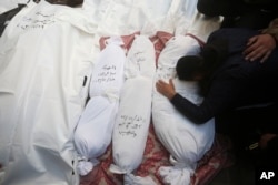 Palestinians mourn relatives killed in the Israeli bombardment of the Gaza Strip outside a morgue in Rafah, Dec. 19, 2023.