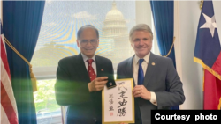 台湾立法院院长游锡堃(左)与美国国会众议院外交事务委员会主席麦考尔众议员会面时，致赠他自己的手写书法“民主必胜”。(2023年5月17日，麦考尔众议员办公室提供)