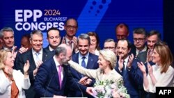 Presiden Partai Rakyat Eropa (EPP) Manfred Weber (tengah, kiri) memberikan bunga untuk Presiden Komisi Eropa Ursula von der Leyen (tengah, kanan) setelah terpilih sebagai kandidat untuk masa jabatan kedua, pada Kongres EPP di Bukares, Rumania, 7 Maret 2024.(Daniel MIHAILESCU/AFP)