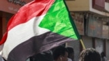 FILE - A man waves a Sudanese national flag while taking part in a march against a deal agreed the previous month between military leaders and some civilian factions on a two-phase political process since the 2021 military coup in Sudan's capital Khartoum on January 24, 2023.