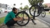 El venezolano Michael Ostis, de 33 años, repara una bicicleta en Bogotá, Colombia, el martes 9 de febrero de 2021. 