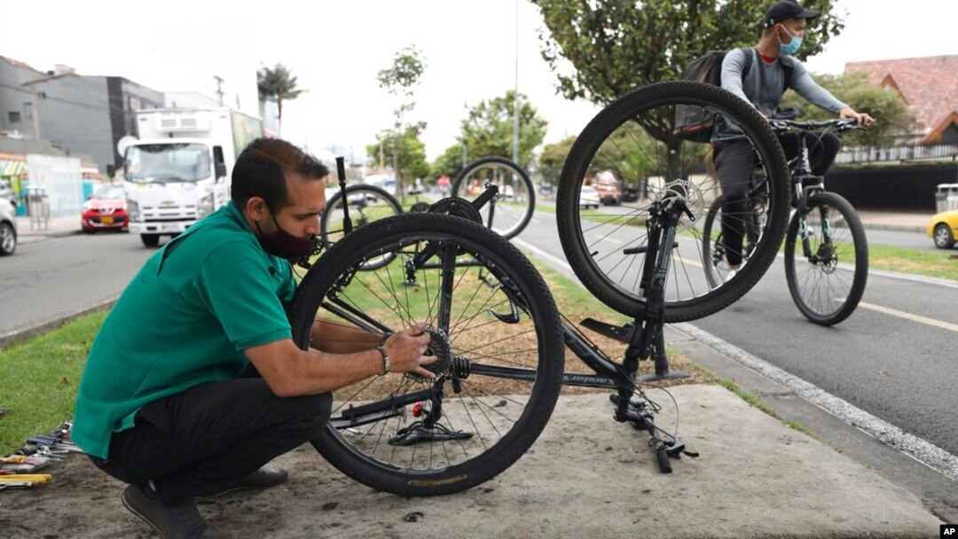El venezolano Michael Ostis, de 33 años, repara una bicicleta en Bogotá, Colombia, el martes 9 de febrero de 2021. 