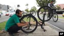 El venezolano Michael Ostis, de 33 años, repara una bicicleta en Bogotá, Colombia, el martes 9 de febrero de 2021. 