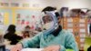 FILE - A student wears a mask and face shield in a fourth-grade class amid the COVID-19 pandemic at Washington Elementary School on Jan. 12, 2022, in Lynwood, California.