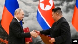 FILE - Russian President Vladimir Putin, left, and North Korea's leader Kim Jong Un exchange documents during a signing ceremony of the new partnership in Pyongyang, North Korea, June 19, 2024.