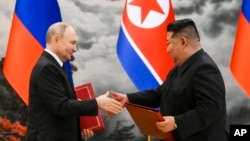 Tổng thống Nga Vladimir Putin (trái) bắt tay Chủ tịch Triều Tiên Kim Jong Un khi trao đổi văn kiện trong lễ ký kết đối tác mới ở Bình Nhưỡng hôm 19/6.