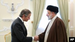 Iranian President Ebrahim Raisi shakes hands with International Atomic Energy Organization, IAEA, Director General Rafael Mariano Grossi at the start of their meeting at the presidency office in Tehran, Iarch 4, 2023. (Iranian Presidency Office via AP)