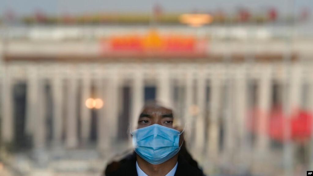 2023年3月3日，北京人民大会堂入口处，一名扮成迎宾员的安保人员站在门口。(photo:VOA)