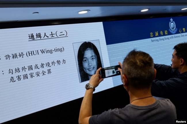 香港当局在记者会上公布被通缉的五名活动人士之一许颖婷的照片。（2023年12月14日）