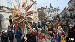 Civilians and soldiers walk through a street as they take part in Christmas Eve procession in Lviv, western Ukraine, Dec. 24, 2023, amid Russia's ongoing invasion of its neighbor.