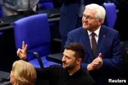 乌克兰总统泽连斯基在柏林对德国联邦议院发表演说后打出象征胜利的手势。(2024年6月11日)