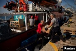 FILE— Open Arms members carry humanitarian aid for Gaza in a joint mission between NGOs Open Arms and World Central Kitchen at a port of Larnaca, Cyprus, March 9, 2024.