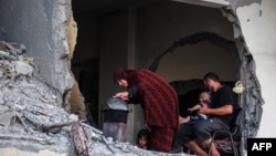 Một gia đình Palestine quây quần quanh bếp củi tạm bợ trong một tòa nhà bị hư hại ở Khan Yunis, phía nam Dải Gaza, vào ngày 4/7/2024.