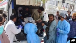 Paramedics and volunteers carry an injured victim of a bomb explosion upon arrival at a hospital, in Quetta, Pakistan, Sept. 29, 2023.