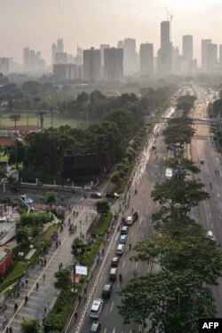 Gedung-gedung pencakar langit diselimuti kabut dan asap polusi yang pekat di Jakarta, 13 Juni 2021. (Foto: Bayu Ismoyo/AFP)