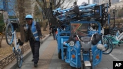 A worker unloads bicycles for a bike-share service in Beijing, China, March 21, 2024.