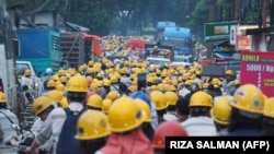 Karyawan perusahaan nikel PT Indonesia Morowali Industrial Park (IMIP) tampak bersiap akan pulang usai bekerja di Konawe, 14 April 2023. (Foto: RIZA SALMAN/AFP)