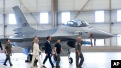 FILE - Ukrainian President Volodymyr Zelenskyy, second right, and Dutch caretaker Prime Minister Mark Rutte, center, look at F-16 fighter jets in Eindhoven, Netherlands, Aug. 20, 2023.