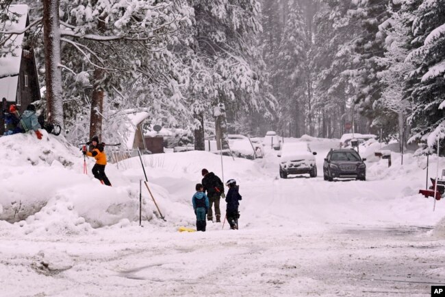 Children play on the snow off Donner Pass Road, March 1, 2024, in Truckee, Calif. The most powerful Pacific storm of the season was forecast to bring up to 10 feet of snow into the Sierra Nevada by the weekend.