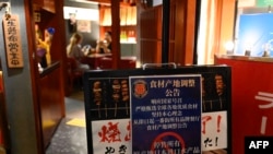 Papan pengumuman yang berbunyi "Menunda semua penjualan produk ikan dari Jepang" terpasang di depan sebuah restoran di Beijing pada 27 Agustus 2023. (Foto: AFP/Pedro Pardo)
