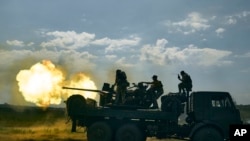 FILE - Ukrainian soldiers fire a cannon near Bakhmut, an eastern city where fierce battles against Russian forces have been taking place, the Donetsk region, Ukraine, May 15, 2023.