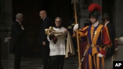 A deacon brings the papal robe for Pope Francis, who will preside over the second vespers in St. Peter's Basilica on Ascension Day, May 9, 2024, after reading the official decree establishing the Catholic Holy Year.