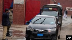 FILE - A police officer salutes a car carrying a judge in Rawalpindi, Pakistan, Jan. 30, 2024. A vehicle carrying three judges was ambushed in Tank, in the Khyber Pakhtunkhwa district, on Aug. 2, 2024, killing two police officers.