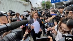 2024年5月30日，香港民主派初选47人案其中一名获判无罪的被告--大律师刘伟聪手持法庭裁决判词被大批传媒包围采访。 (美国之音照片)