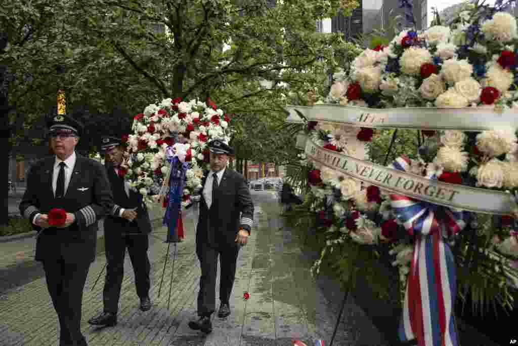 Personas llevan una corona fúnebre a la ceremonia conmemorativa de los ataques terroristas del 11 de septiembre de 2001, en Nueva York.&nbsp;