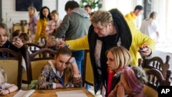 Nina Poliakova speaks to her foster daughter Olha Hinkina at the recovery camp for children and their mothers affected by the war near Lviv, Ukraine, Wednesday, May 3, 2023.