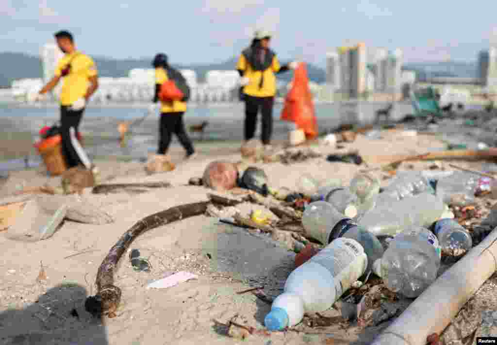 La crisis climática afecta a todo el mundo. En George Town, Malasia, las botellas de plástico yacen varadas en una playa, por lo que voluntarios limpian el lugar como parte de las celebraciones del Día de la Tierra.