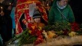 资料照片：2023年4月30日在乌克兰中部乌曼举行的葬礼上，米凯尔·舒尔哈（中）在他 11 岁的姐姐索菲亚·舒尔哈的棺材旁哭泣。索菲亚是俄罗斯袭击该市一栋住宅楼的遇难者之一。