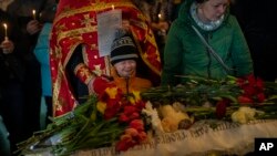 2023年4月30日在烏克蘭中部烏曼舉行的葬禮上，米凱爾·舒爾哈（中）在他11 歲的姐姐索菲亞·舒爾哈的棺材旁哭泣。索菲亞是俄羅斯襲擊該市一棟住宅樓的遇難者之一。