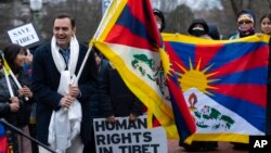 Representative Mike Gallagher, R-Wis., holds a Tibetan flag during a rally to commemorate the failed 1959 Tibetan uprising against China's rule, outside of the Chinese Embassy in Washington, Friday, March 10, 2023. 