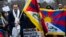 Representative Mike Gallagher, R-Wis., holds a Tibetan flag during a rally to commemorate the failed 1959 Tibetan uprising against China's rule, outside of the Chinese Embassy in Washington, Friday, March 10, 2023. 