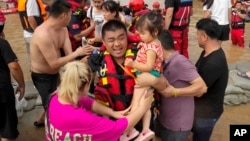 FILE - Rescuers using rubber boats evacuate trapped residents through floodwaters in Zhuozhou in northern China's Hebei province, south of Beijing, Aug. 2, 2023.