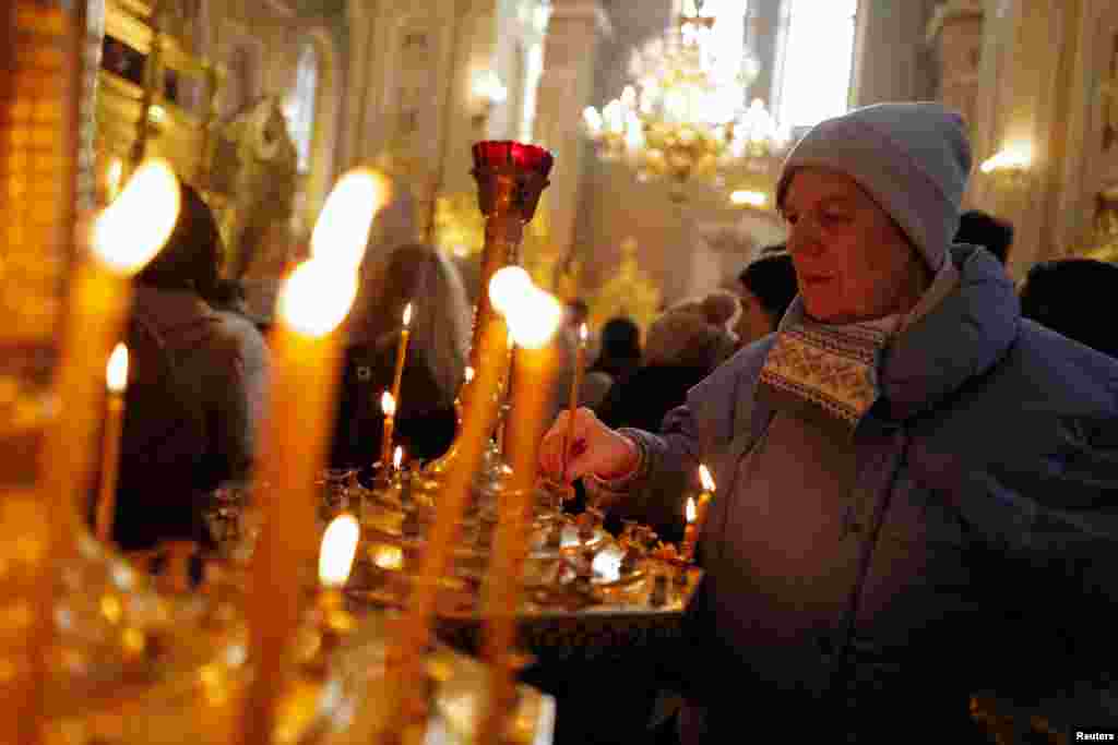 Otra ucraniana en Polonia es Svitlana Skibina, de 62 años, fotografiada mientras enciende una vela durante la misa en una iglesia en Varsovia. Skibina huyó de Kharkiv en abril pasado con su esposo discapacitado, su hijo, su nuera y su nieta.