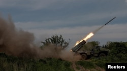 Ukrainian servicemen fire a BM-21 Grad multiple launch rocket system towards Russian troops during Russia's attack on Ukraine near the frontline town of Bakhmut, Ukraine, May 19, 2023. (Radio Free Europe/Radio Liberty/Serhii Nuzhnenko/Reuters)