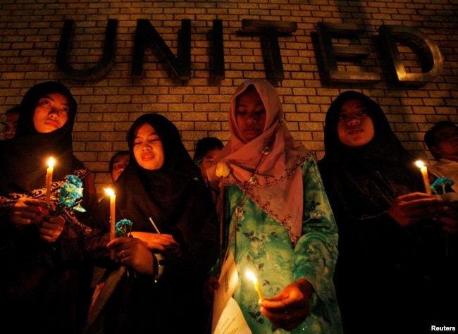 FILE - Thai-Muslim students hold a candlelight vigil for victims of the Tak Bai shooting on its third anniversary, outside the United Nations building in Bangkok, Oct. 25, 2007.